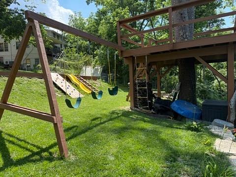 The backyard boasts a variety of activities for all ages including a multi-purpose court with gear for bocce, badminton, and soccer practice, a fire pit, tree fort with swings, slide, climbing wall, and geodesic climbing structure.
