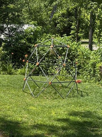 The backyard boasts a variety of activities for all ages including a multi-purpose court with gear for bocce, badminton, and soccer practice, a fire pit, tree fort with swings, slide, climbing wall, and geodesic climbing structure.