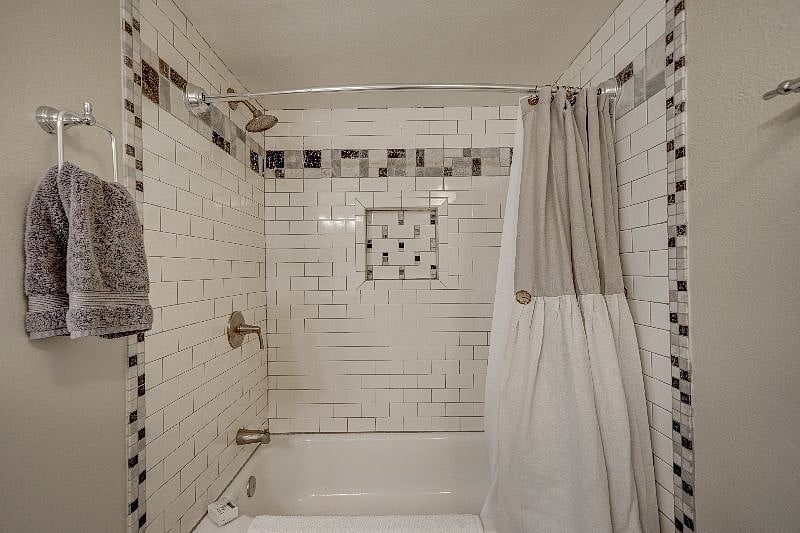 Bathroom has a shower and tub and lots of cabinet space