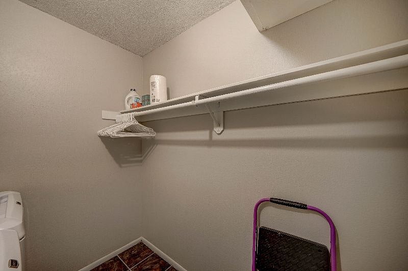 In-unit laundry room with shelving and a place to hang clothes