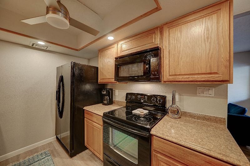 Galley style kitchen is fully stocked and has a dishwasher, stove and microwave