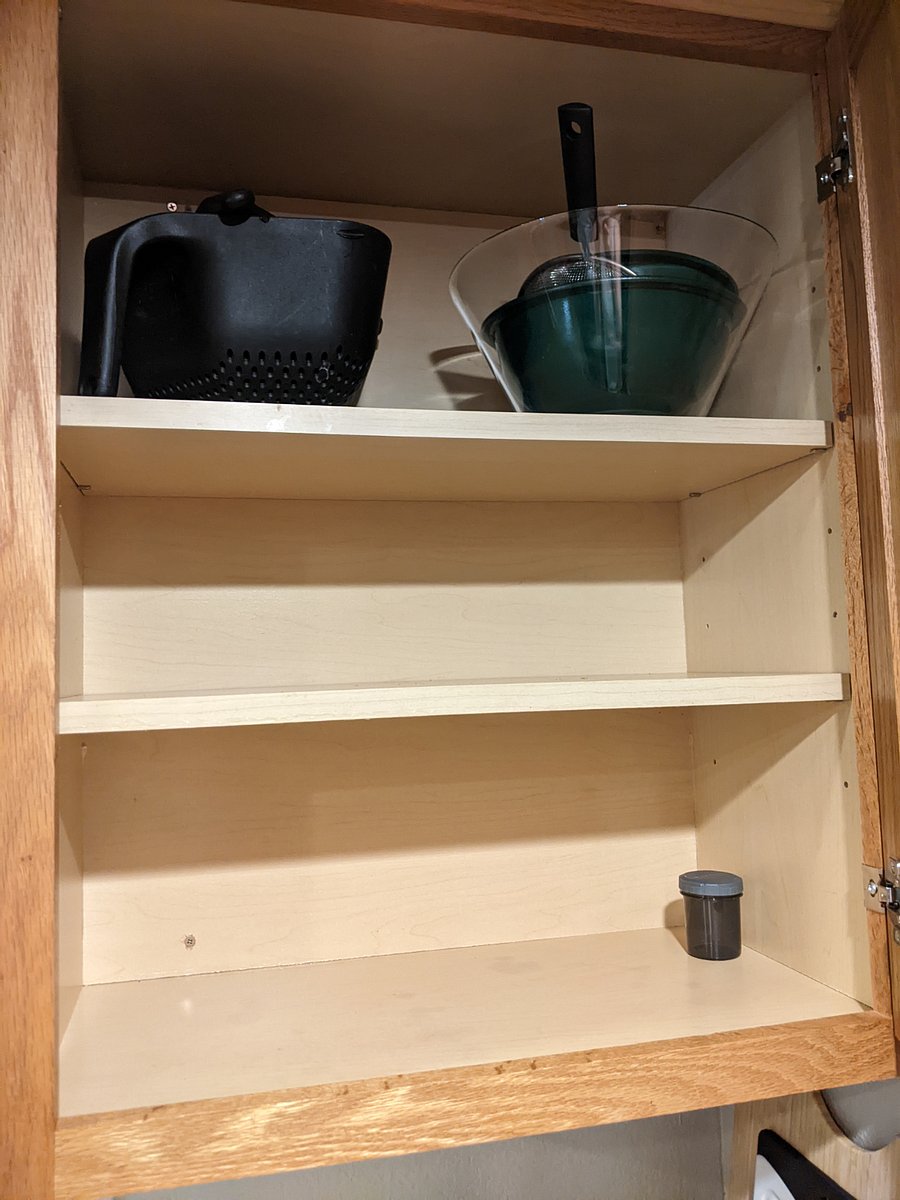 Fully stocked kitchen with mixing bowls and a strainer 