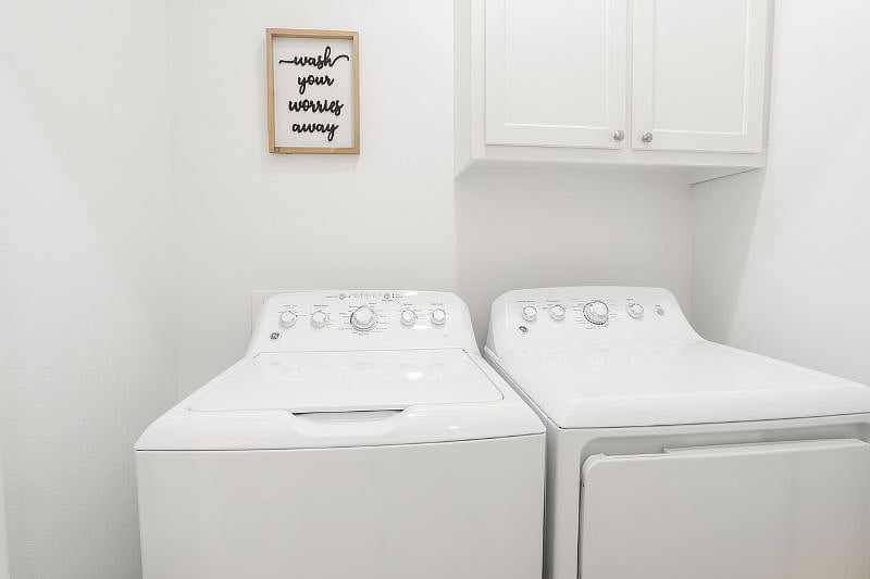 Full sized washer and dryer in laundry room 