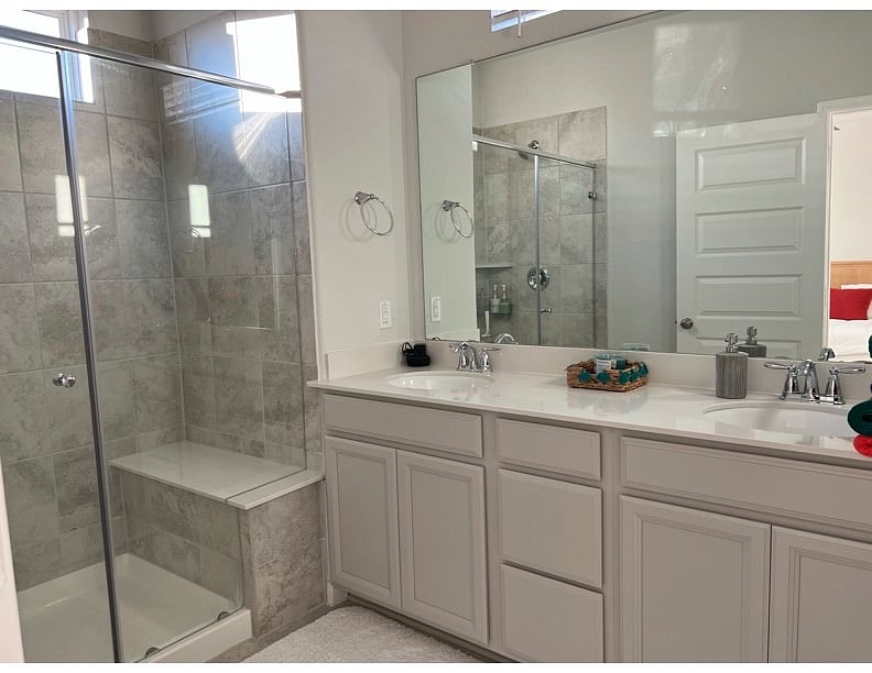 spacious stand up shower with his and hers sink
