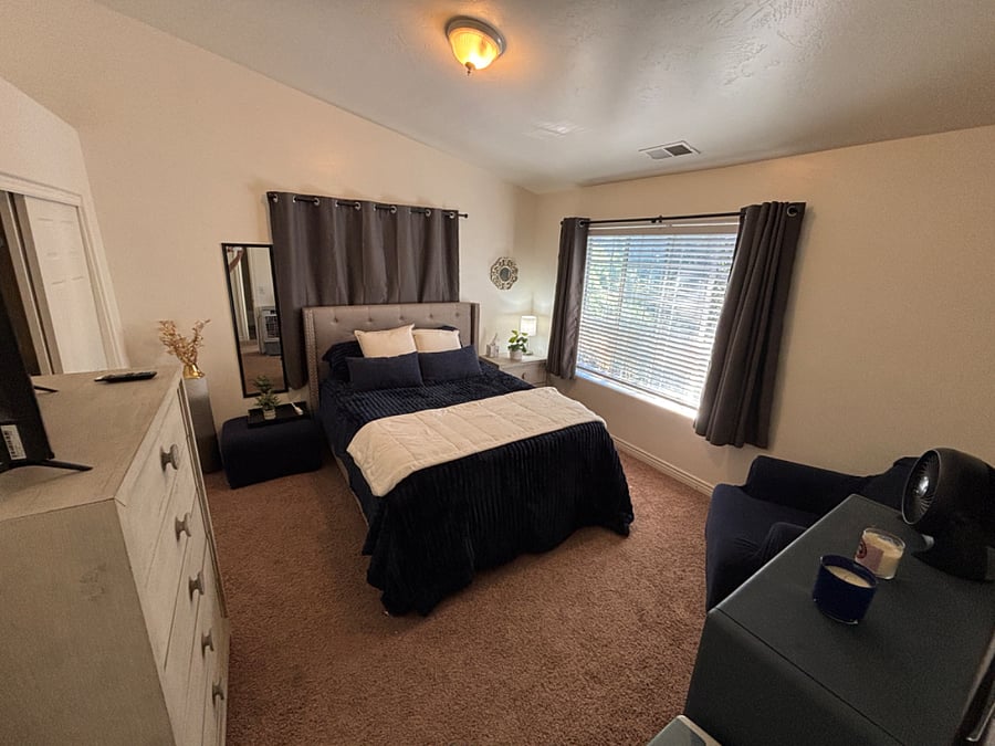 Bedroom 3 has queen bed, dressers, closet, smart TV and cozy chair and bookcase.
