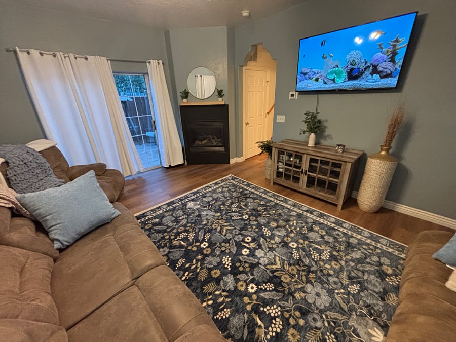 Comfy living room with tons of seating, modern furnishing and mounted smart TV.