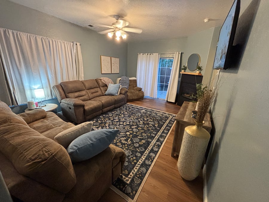 Comfy living room with tons of seating, modern furnishing and mounted smart TV.