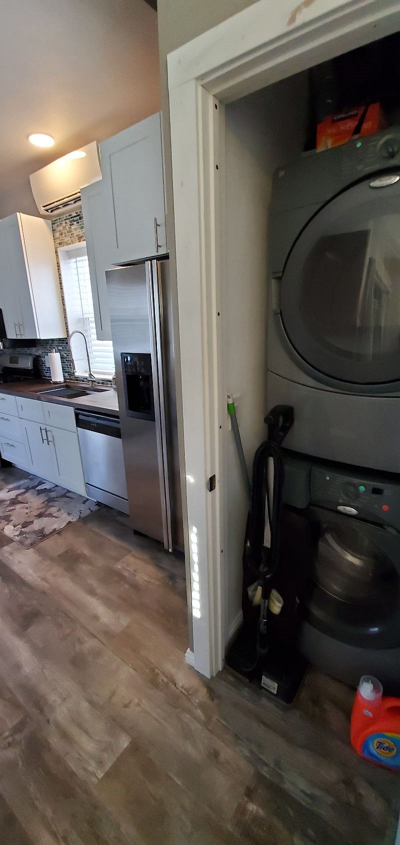 Laundry Closet with full size Whirlpool front load washer and dryer.  Oreck vacuum & Swiffer. Full-size ironing board and iron.