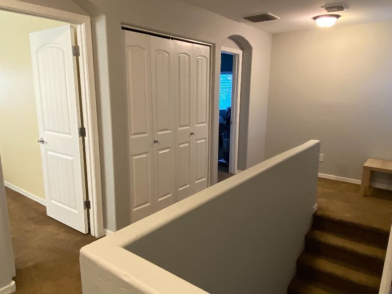 upstairs hallway showing bedroom 1, 2 and laundry behind closet doors