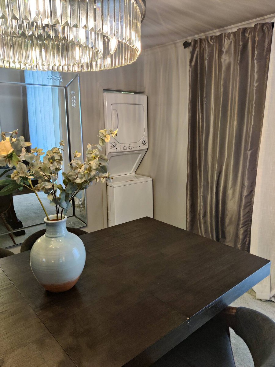 A solid walnut dining table thats perfect for both meals and work, complemented by a beautiful chandelier to add a touch of light and elegance when needed.