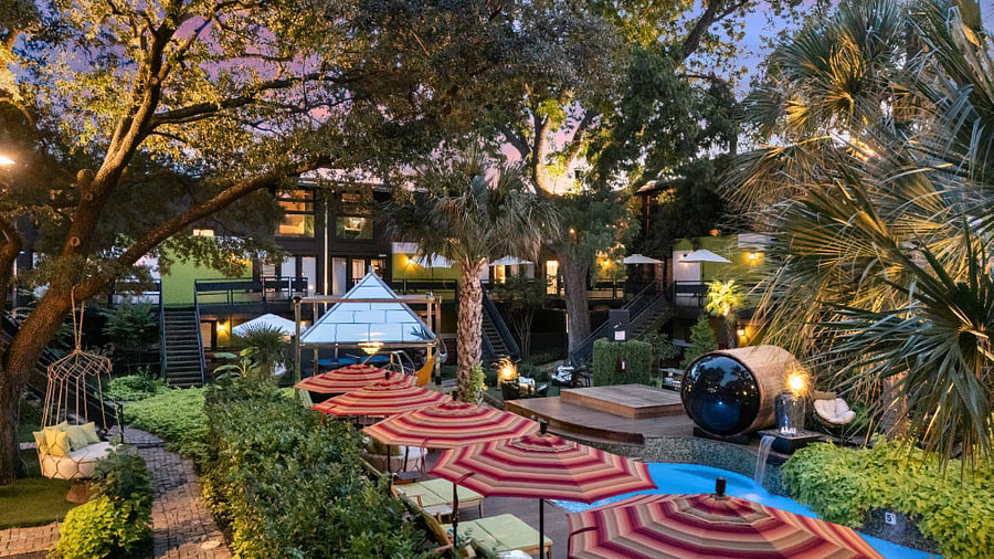 Resort style courtyard with striped umbrellas and garden paths. Wellness products available for our residents. 