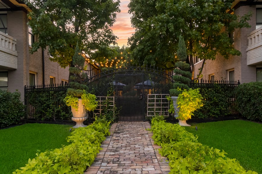 Welcoming pathway framed by lush landscaping and warm evening lights.
