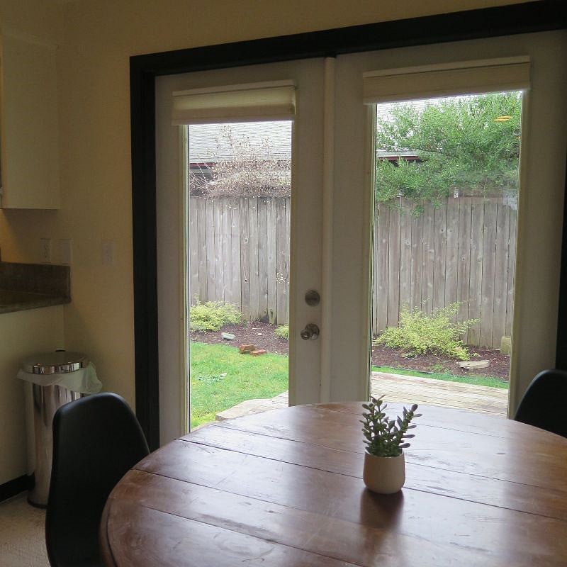 Dining table next to French doors that open to back yard