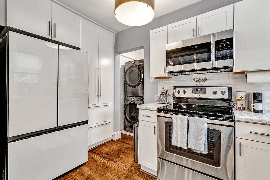 Fully equipped kitchen with a Bespoke fridge, stainless steel appliances and in-unit laundry machines.
