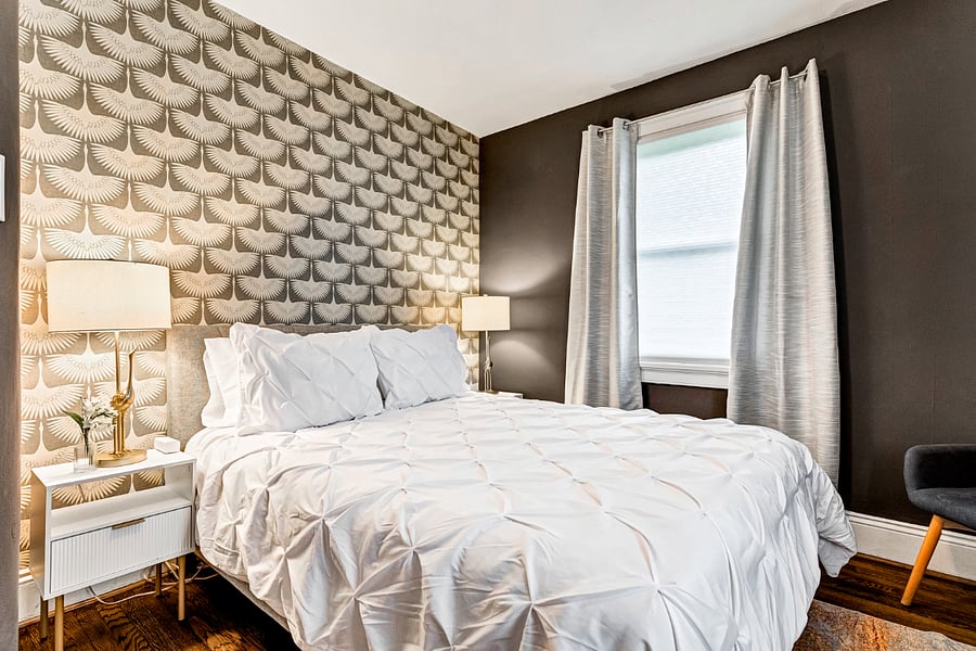 The silver bedroom with soft bedding, stylish decor and blackout curtains.