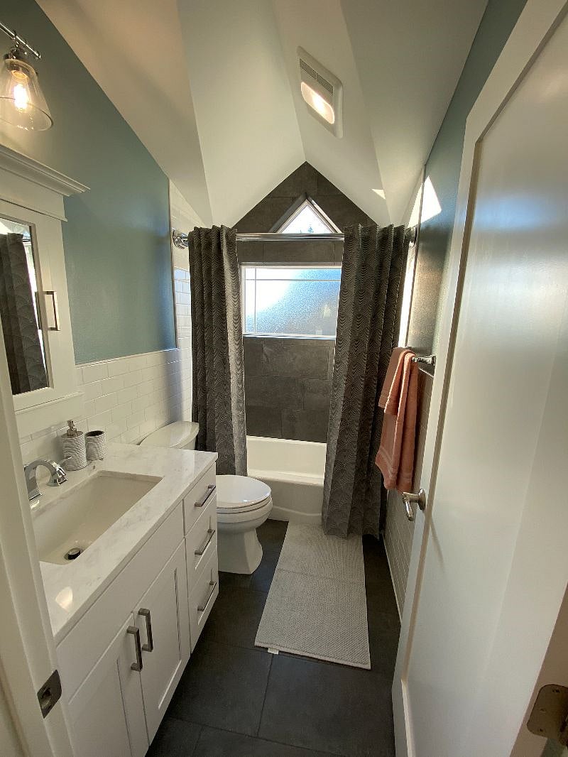 Built-in medicine cabinet surrounded by tile wainscoting.