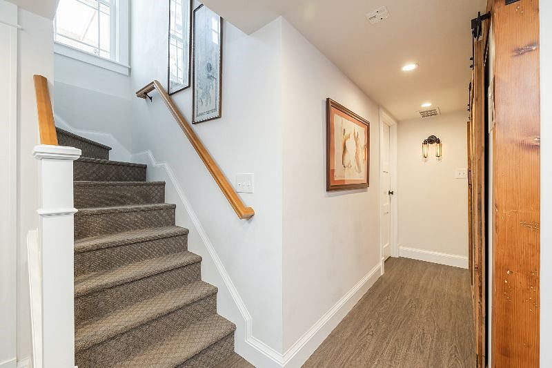 Hallways looking from kitchenette area to guest suite (R) and to the exit (up the stairs). stairs appear narrower than they actually are.