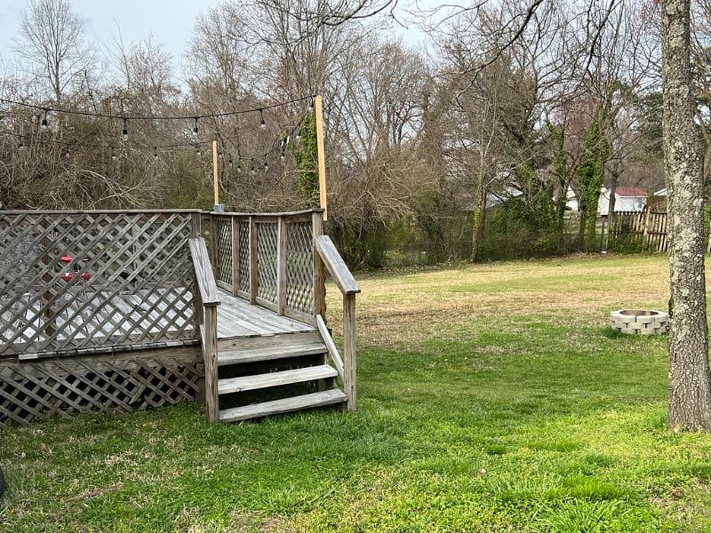 Large Backyard equipped with fire-pit and patio furniture. 