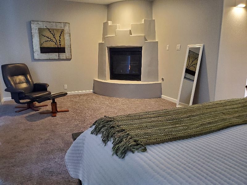 Spacious master bedroom with fireplace and sitting area.