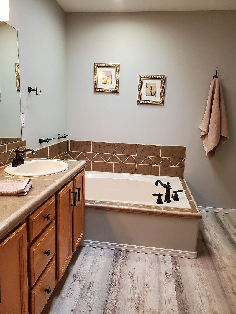 Master bath features a soaking bathtub, and shower with glass door.