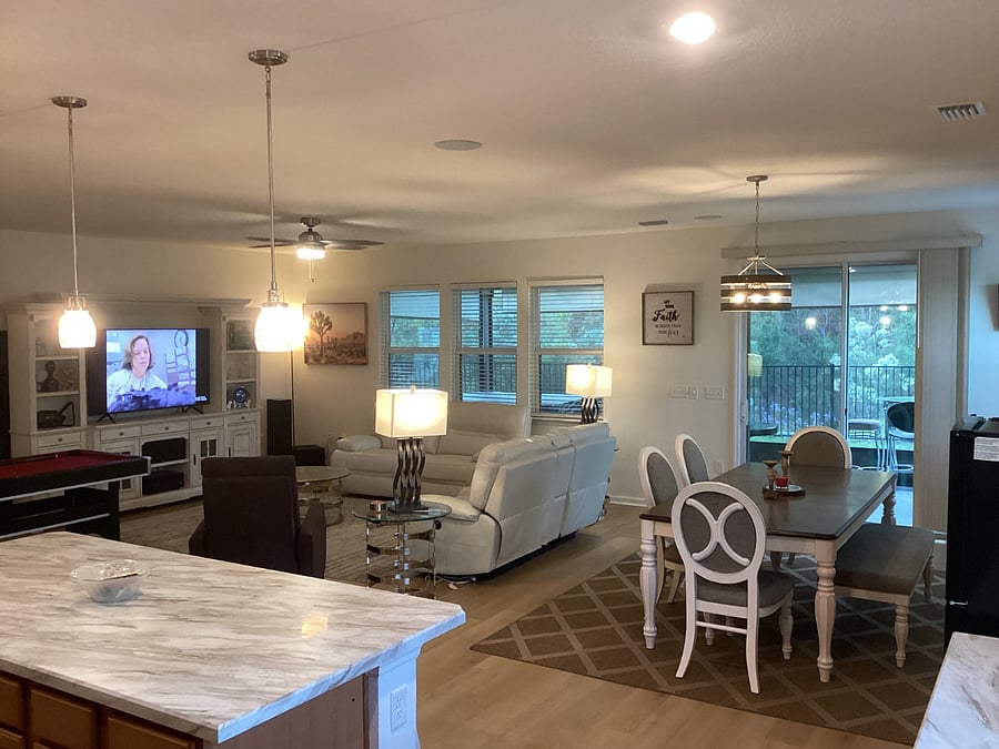 LOUNGE & DINING AREA - View of TV display units, large TV, sofa, chairs and lamps, pool table, windows and french doors - leading to patio.