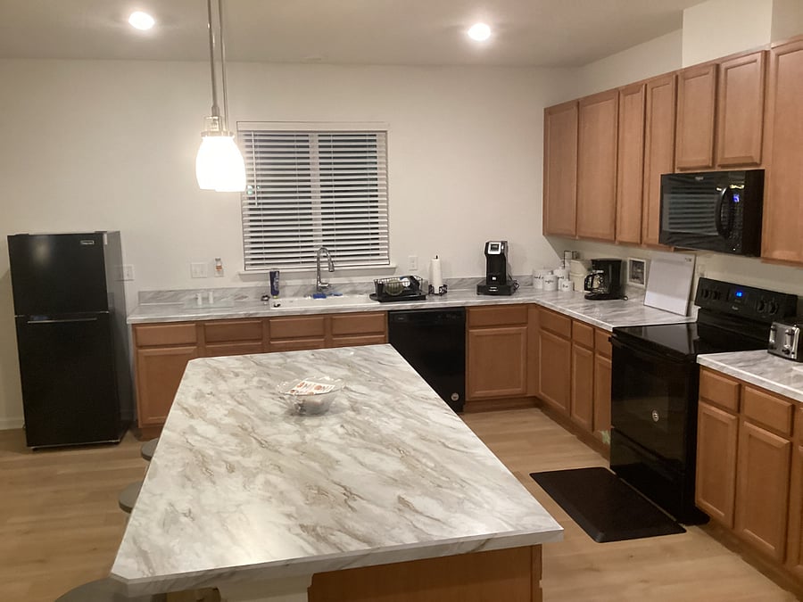 KITCHEN AREA - View of Kitchen breakfast island, kitchen work counter, top and bottom cabinets, appliances and window.