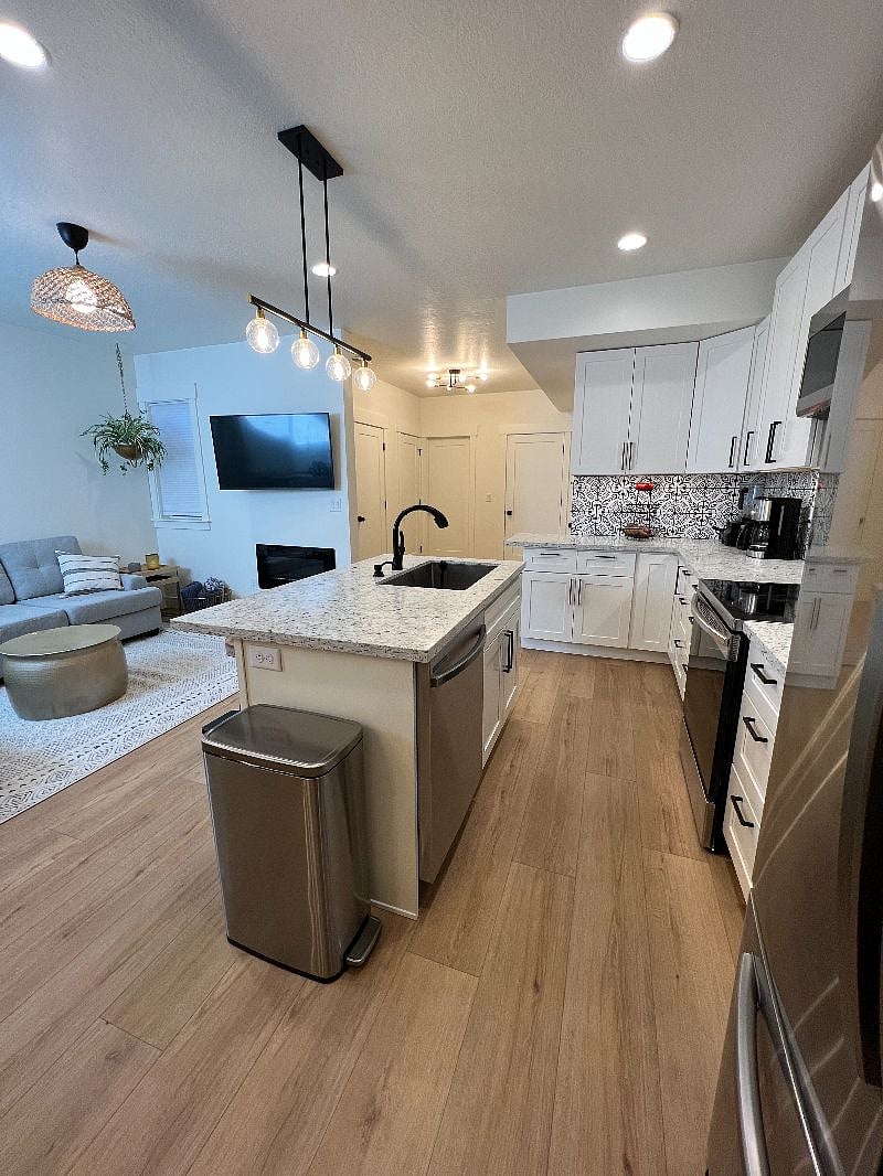 Quartz countertops and extra large sink. Use of numerous small kitchen appliances.