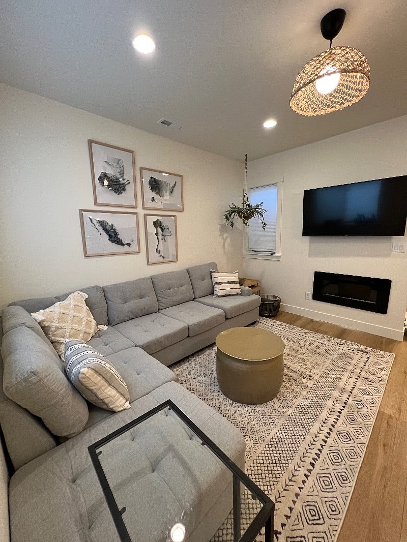 55" TV, electric fireplace and newer couch in the living room. 