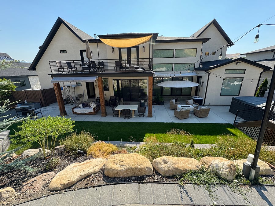 backyard w/ waterfall, wood firepit and gas fire feature. Patio swing and dining table.