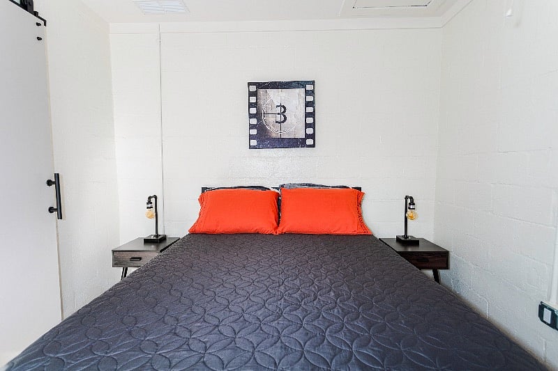 Bedroom and end tables with vintage industrial lamps lit by Edison bulbs. The lamps are dimmable and equipped with USB ports.