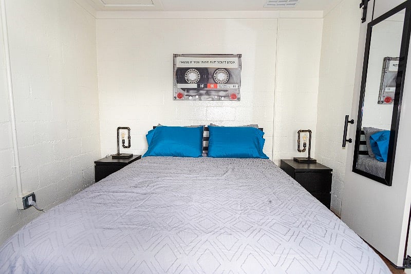 Bedroom and end tables with vintage industrial lamps lit by Edison bulbs. The lamps are dimmable and equipped with USB ports.
