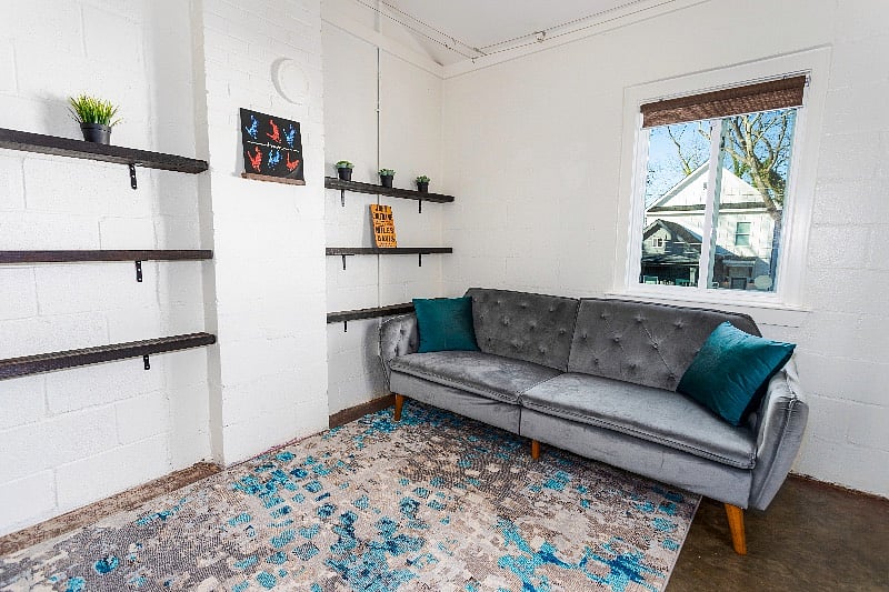 Living room with plush velvet couch and pillows. Converts to a queen sized sofa bed.
