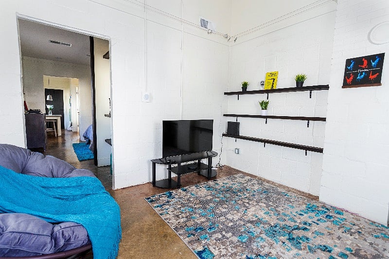Living room with vintage music props on the bookshelves. Enjoy this 42" smart TV for streaming your favorite shows with our high-speed WiFi.