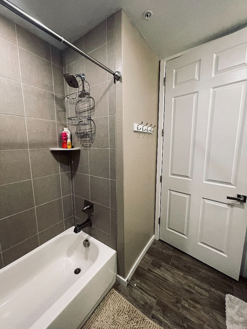 Bathroom with shower, tub, and towel hooks