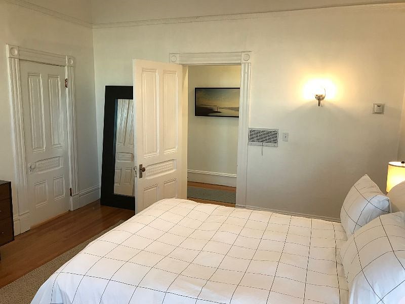 Large, well-lit bedroom with new linens, ample storage, and big closet (closed door on left)