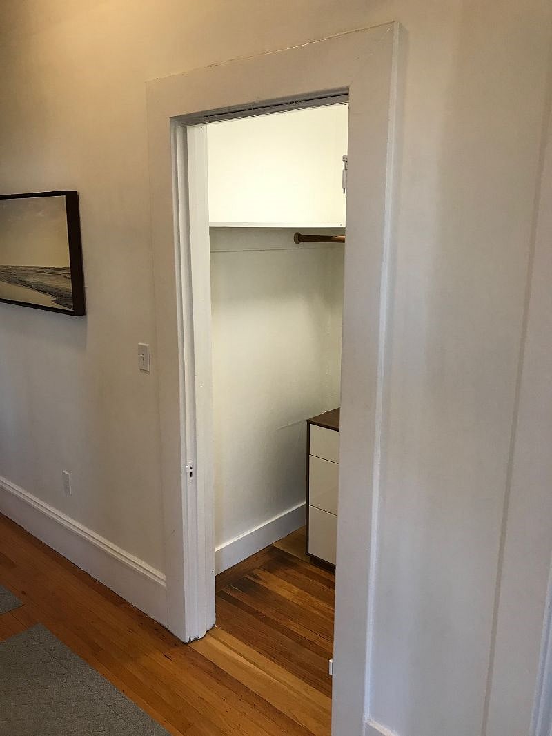 Huge hall closet with shelves and dresser