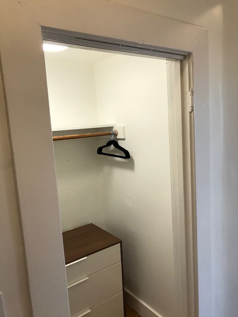 Huge hall closet with shelves and dresser