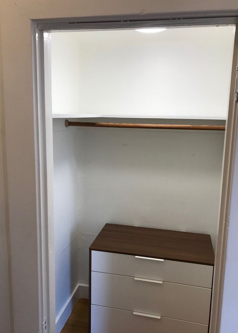 Huge hall closet with shelves and dresser