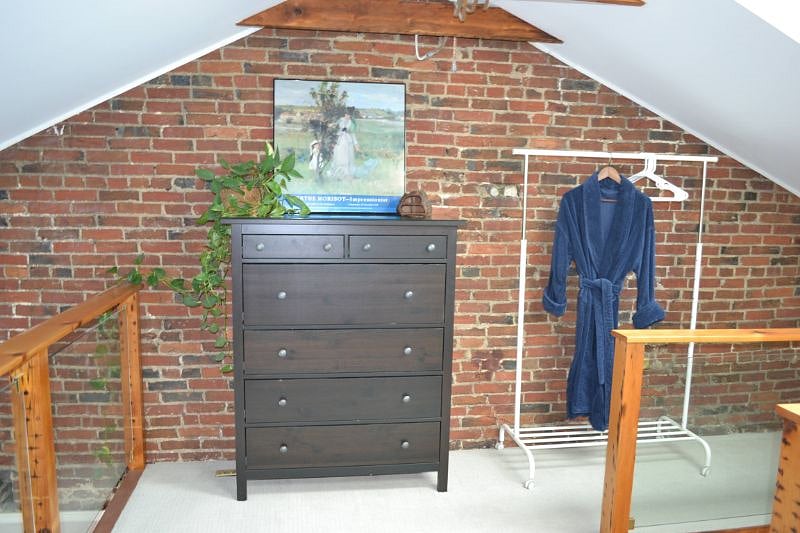 Large loft bedroom has full size dresser.
