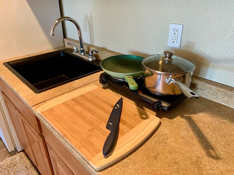 Sleek black sink, kitchenware and cookware.