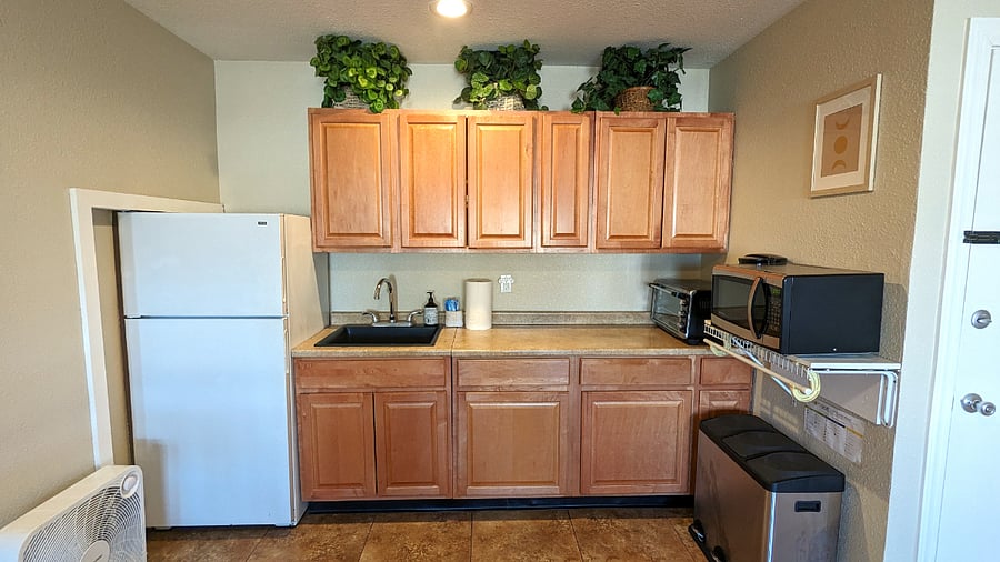 Open concept kitchenette with cookware, kitchenware, etc.