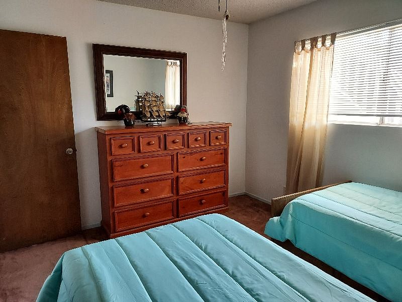 twin beds room with dresser and mirror