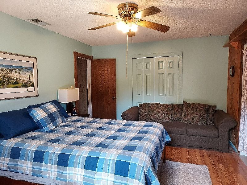 Master bedroom queen bed and couch.