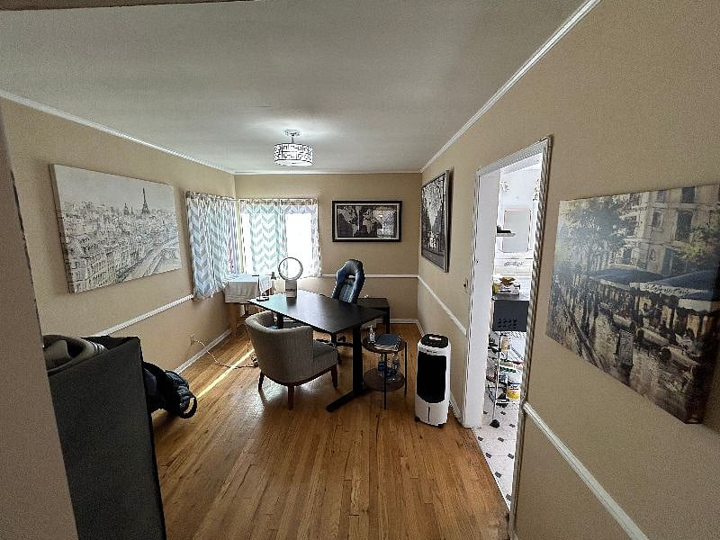 Dining room space which has been converted into an office space, with nice desk, cozy gaming chair, and nice wall art...all by the windows.