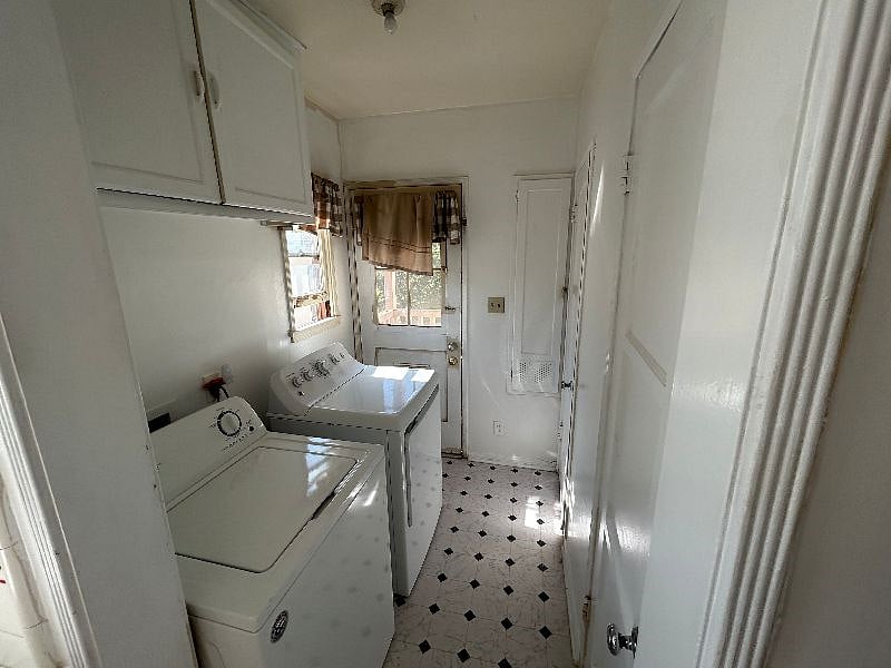 A great laundry room, with a huge storage closet across from washer, additional storage above the washer/dryer, and a fold-down ironing board next to light switches.