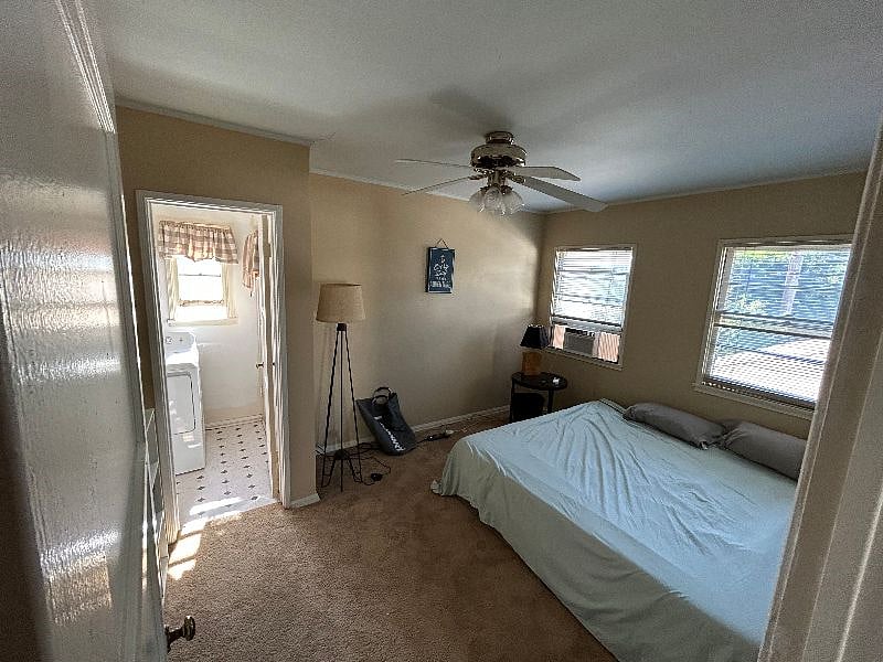 Guest bedroom, entering from the hallway. You see it goes directly to laundry room which then leads to the kitchen. King bed, and brand new AC window unit installed Summer 2023.
Also, bedroom was freshly painted in Summer 2023, and new carpeting was installed in Summer 2023 as well.