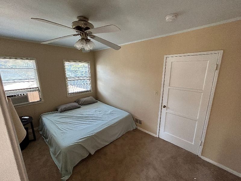 Guest bedroom, entering from the laundry room. Note the bedroom walls and doors all newly painted as of 2023, and brand new carpet in both bedrooms and hallway connecting the bedrooms.