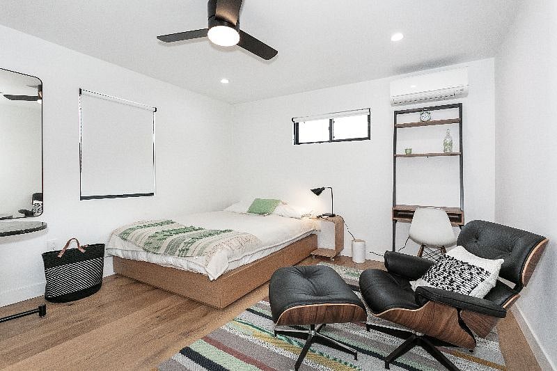 A lovely queen bed, along with a small desk for work at home with lots of natural sunlight.