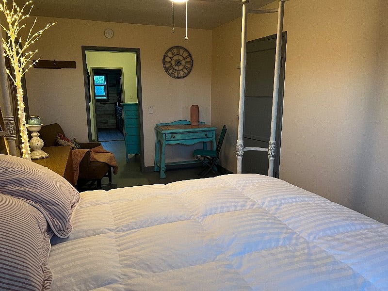 another shot of bedroom (two windows with AC unit) hallway with closets, drawers adjoining bathroom