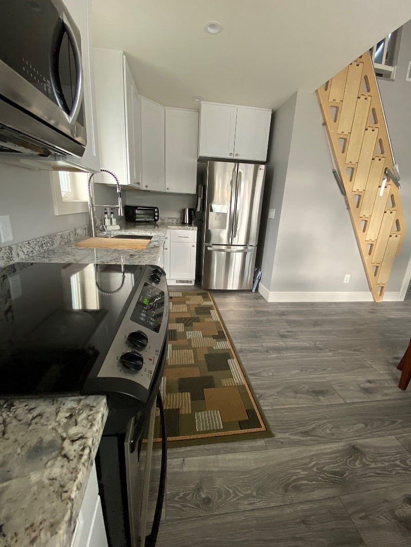 Electric stove and oven, microwave, full sized refrigerator, small dishwasher, sink, countertop appliances 